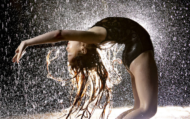 Dancer arching back in rain