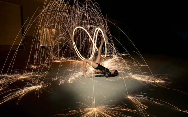 Dancer with leg up with sparks flying